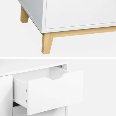 A close-up view of a white dresser with wooden legs and an open drawer.