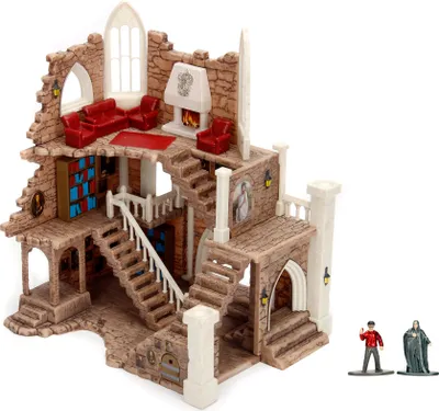 A miniature model of a castle tower with furniture and figures.