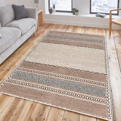 A rug is placed on a wooden floor in a living room setting, next to a sofa.