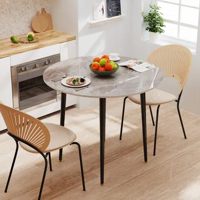 A round marble-look dining table with two chairs in a kitchen setting.