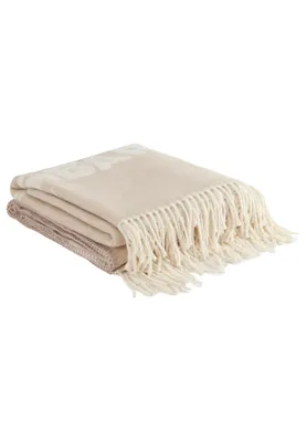 A folded blanket with fringe detail.