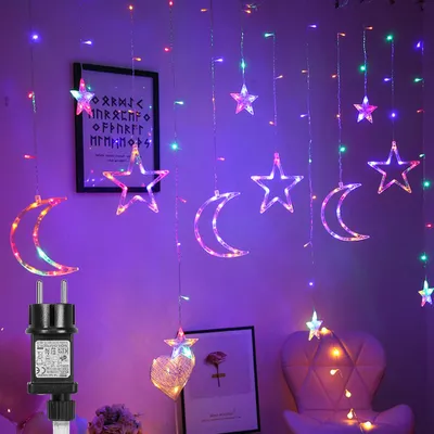 A room decorated with colorful LED string lights shaped like stars and moons, with a chair and framed pictures in the background.