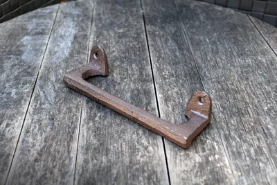 A cast iron handle resting on a wooden surface.