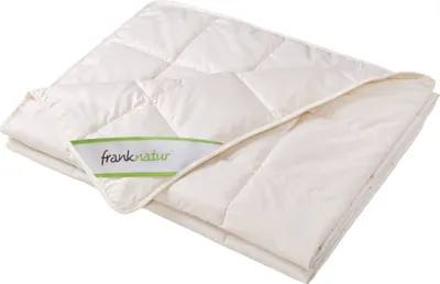 A folded cream-colored blanket with a green and white label.