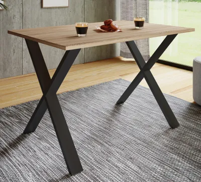 A dining table with two glasses of coffee and cookies on it, placed on a rug in a room with a window.