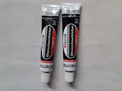 Two tubes of 'Ofenschnurkleber' (oven seal adhesive) are shown side-by-side against a light gray background.