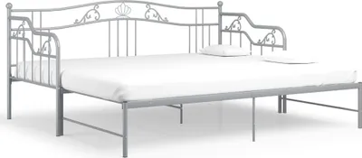 A gray metal daybed with a white mattress and two white pillows against a white background.