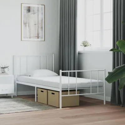 A white metal bed frame with a mattress and two storage boxes underneath, placed in a bedroom setting with curtains and a window in the background.