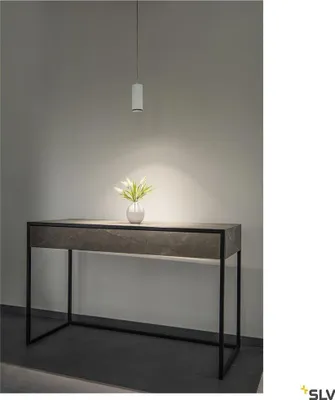 A modern console table with a marble-like top and black metal legs, illuminated by a pendant light. A small vase with greenery sits on the table.