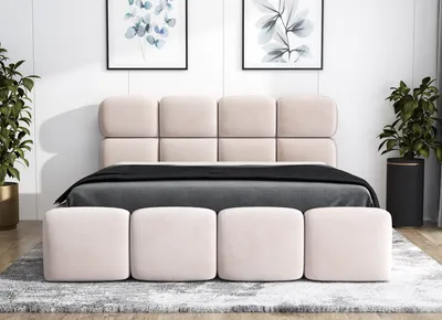 A bedroom scene with a bed, headboard, and ottomans.