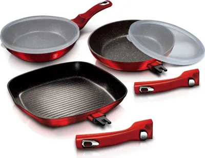 A set of red cookware with detachable handles and lids, displayed on a white background.