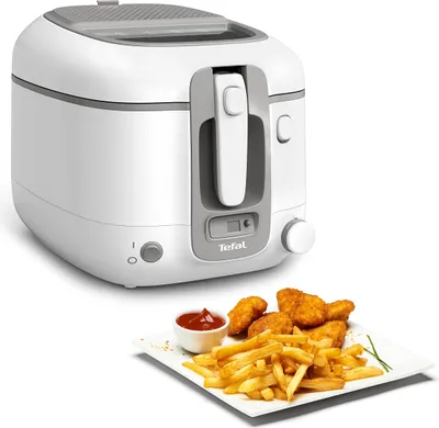 A white and gray Tefal deep fryer is shown next to a plate of french fries and chicken nuggets with ketchup.