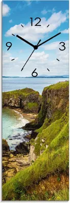 A vertical clock face with a landscape image of a coastal cliff and sea.