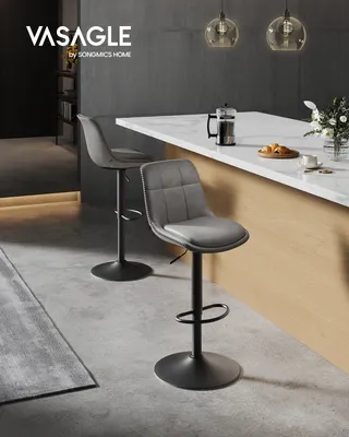Two gray bar stools are shown in a modern kitchen setting, with a marble countertop and wooden cabinets.