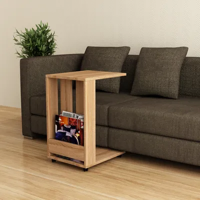 A wooden side table with magazines is placed next to a sofa.