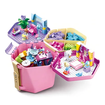 A toy construction set with multiple compartments filled with building blocks and assembled scenes, including figures and accessories.
