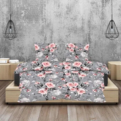A bed with a floral print duvet and pillows, set against a textured gray wall with pendant lights.