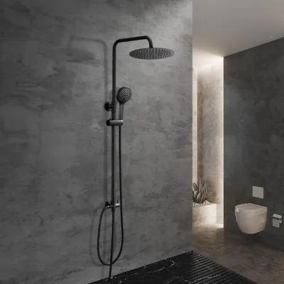 A modern bathroom with a black shower system against a textured gray wall, and a white toilet in the background.
