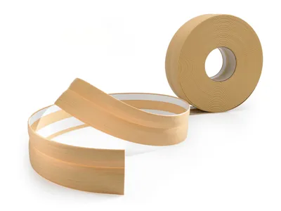 A roll of self-adhesive PVC skirting board with a wood-like finish and a section unrolled in the foreground.