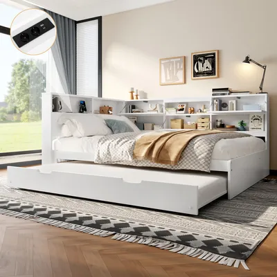 A white daybed with a pull-out trundle bed, set up in a bedroom with a large window and decorative artwork on the wall.