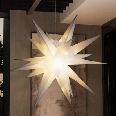 A large, illuminated star-shaped lamp hangs from the ceiling in a modern indoor/outdoor space.