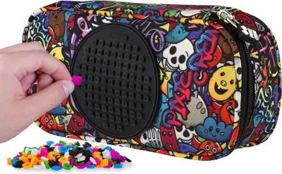 A hand is placing a small pink bead onto a black pegboard attached to a pencil case with a graffiti pattern.