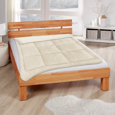 A bed with a duvet in a bedroom setting.