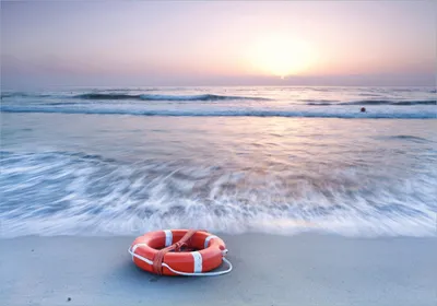 Produktbild von Wallario Poster - Rettungsring am Strand bei Sonnenuntergang, Kunstdruck Größe: 70 x 100 cm