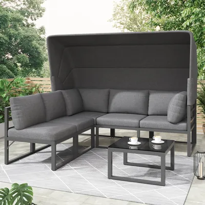 An outdoor lounge set with a canopy, sofa, and coffee table on a patio.