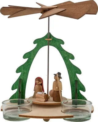 Das Bild zeigt ein Bastelset für eine Pyramide aus Holz mit zwei Figuren unter einem grünen Bogen und einem Propeller an der Spitze sowie zwei Teelichthaltern an der Basis