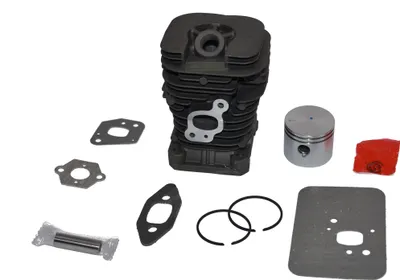 A collection of chainsaw engine parts, including a cylinder, piston, rings, and gaskets, laid out on a white background.
