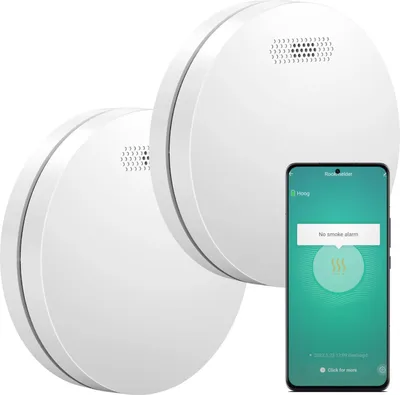 Two white smoke detectors are shown with a smartphone displaying a smoke alarm app.