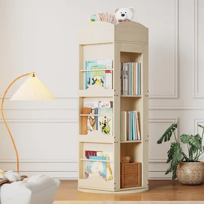 A rotating bookshelf filled with books and a teddy bear on top, placed in a room with a floor lamp and a plant.