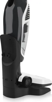 A close-up side view of a cordless stick vacuum cleaner on its charging base.