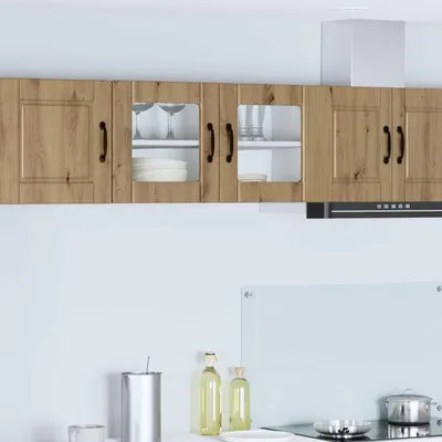 A kitchen scene with overhead cabinets, a range hood, and countertop items.