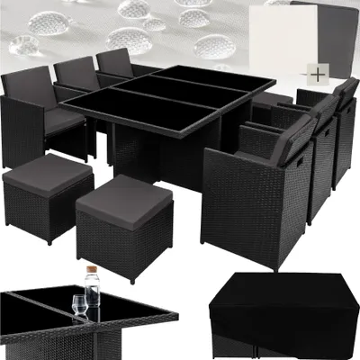 A rattan garden furniture set with a glass-topped table, chairs, and ottomans, along with a protective cover.