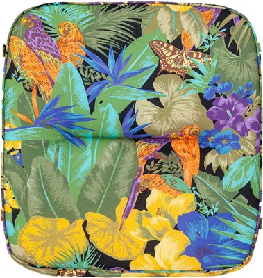 A close-up view of a cushion with a tropical pattern featuring parrots, flowers, and leaves.