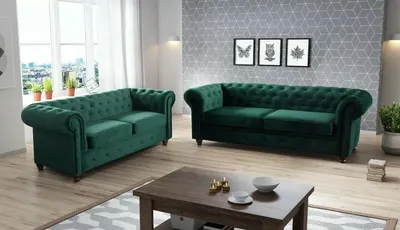 A living room scene with two green velvet chesterfield sofas and a coffee table.