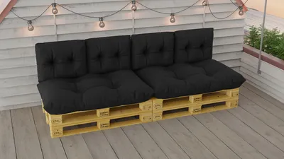 A black pallet sofa set with cushions on a wooden deck.