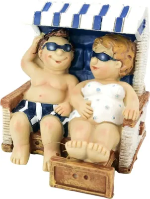 A figurine of a couple sitting in a beach chair.
