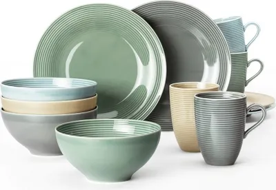 A collection of ceramic tableware including plates, bowls, and mugs in various muted colors.