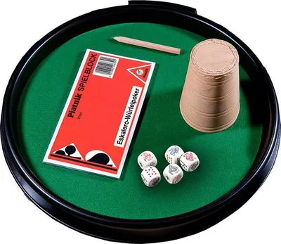 A game set with dice, a cup, a pencil, and a score pad on a green felt surface within a black rim.