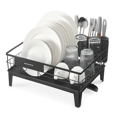 A black dish drying rack filled with white plates, glasses, and cutlery, set against a white background.