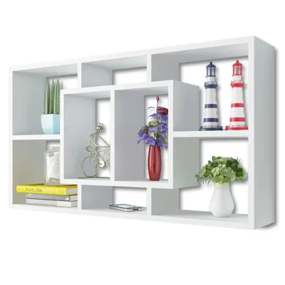 A white wall shelf with various compartments, displaying decorative items.