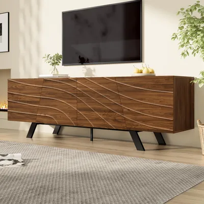 A TV stand with a wavy front design is shown in a living room setting, with a TV mounted above it and a rug in the foreground.