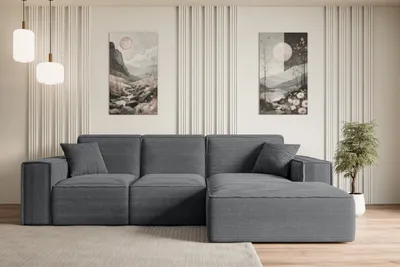 A modern living room with a gray sectional sofa, two abstract landscape paintings on the wall, and pendant lights.