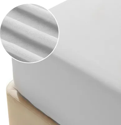 A close-up view of a gray fitted sheet on a bed.