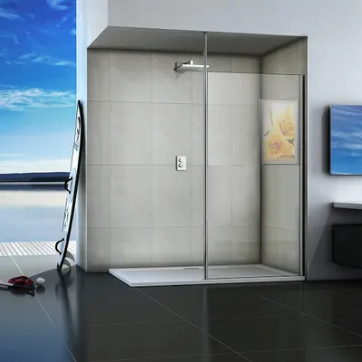 A modern walk-in shower enclosure with a glass door and silver frame, set against a tiled wall and a backdrop of a bright blue sky and water.
