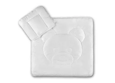 A white baby bedding set with a teddy bear motif, including a blanket and a pillow, laid out on a white background.