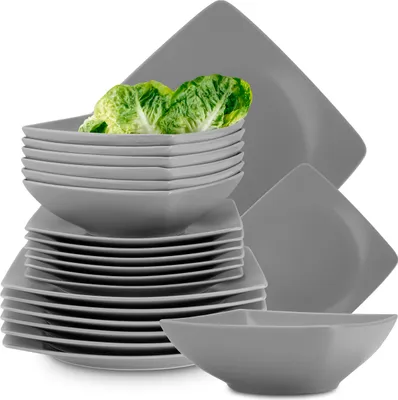 A stack of grey square plates and bowls, with some lettuce leaves placed in the top bowl.